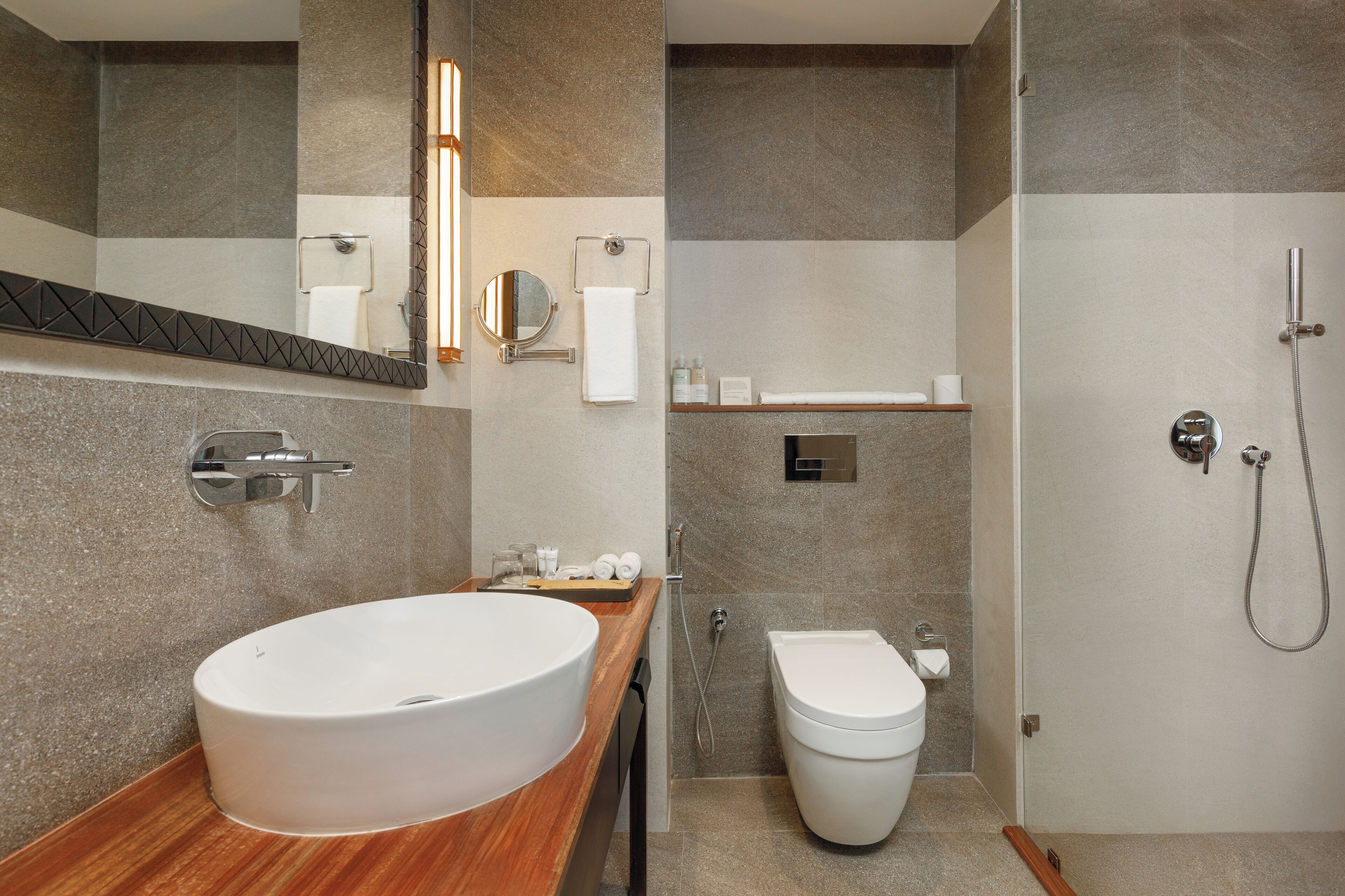Un bagno moderno con un ampio lavabo ovale, un water e una doccia.
