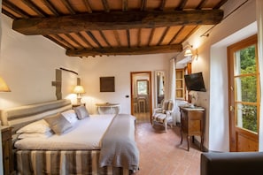 A bedroom with a large bed, a desk, a chair, and a TV. - Villa Chianti | Luxury Pool, Jacuzzi Tub, Sauna and Chromoterapy (Greve in Chianti)