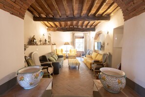 A cozy living room with a fireplace, comfortable seating, and decorative items.