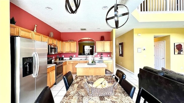 A modern kitchen with wooden cabinets, stainless steel appliances, and a central island.