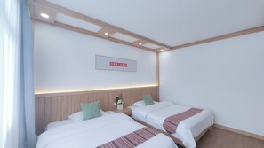 A hotel room with two beds, wooden headboard, a sign on the wall, and a nightstand with a flower vase. - Breeze & Alley Inn (Zhangjiajie)
