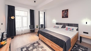 A modern bedroom with a large bed, a desk, and a chair. - Ataraxya Premium Residence (Brasov)