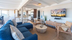 Ein modernes Wohnzimmer mit einem blauen Sofa, einem runden Couchtisch und einem Holzstuhl.