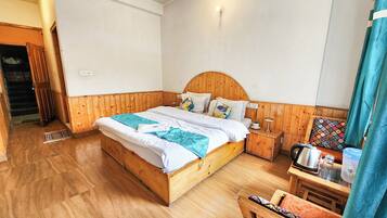 A wooden-paneled bedroom with a bed, bedside table, and a chair.