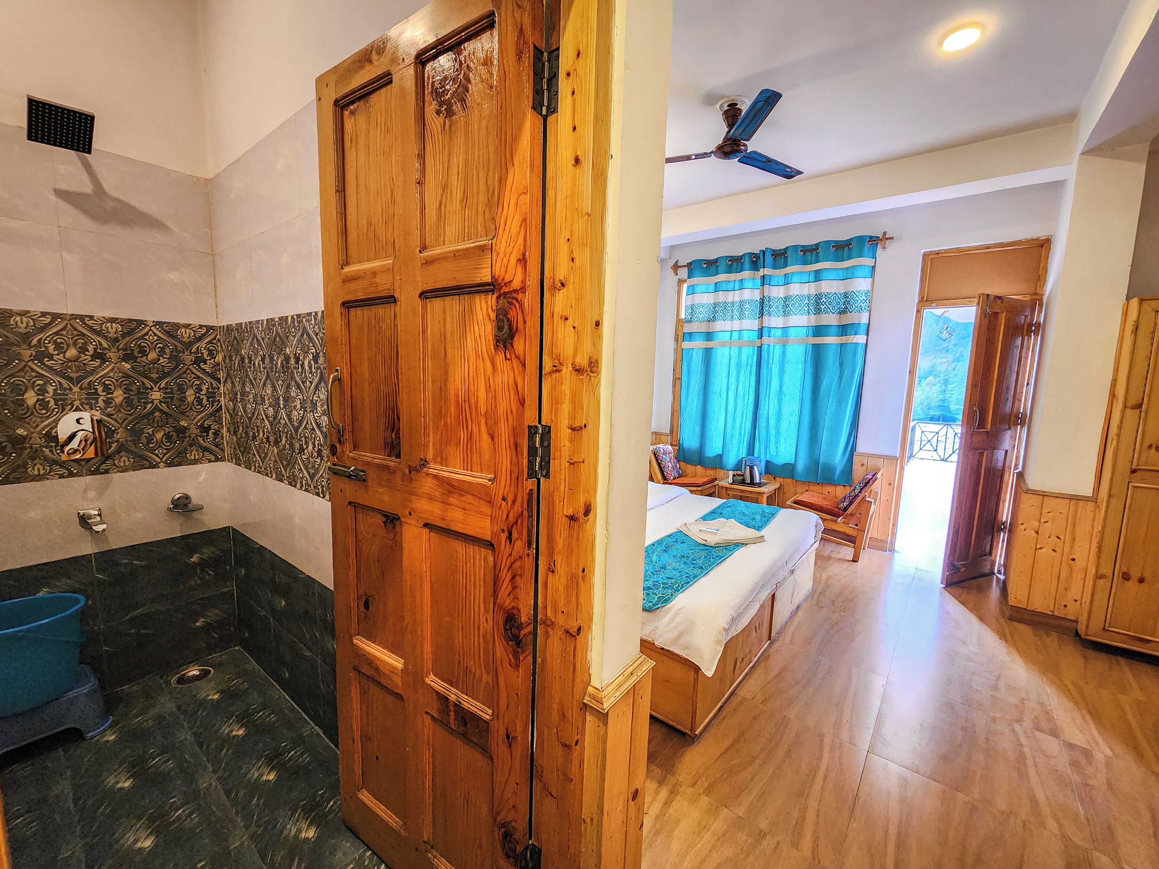 Un baño con puerta de madera, bañera y ducha.