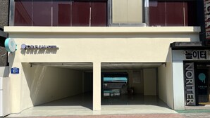 A hotel with a sign reading "CREAM HOTEL" and a parking garage entrance. - Cream Hotel (Guri)