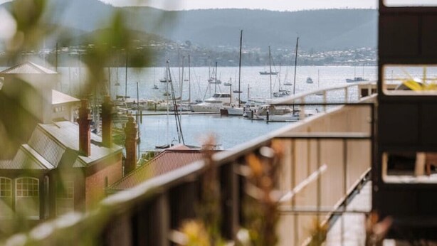 A balcony with a view of a marina and distant hills. - The Perfect Apartment (Sandy Bay)