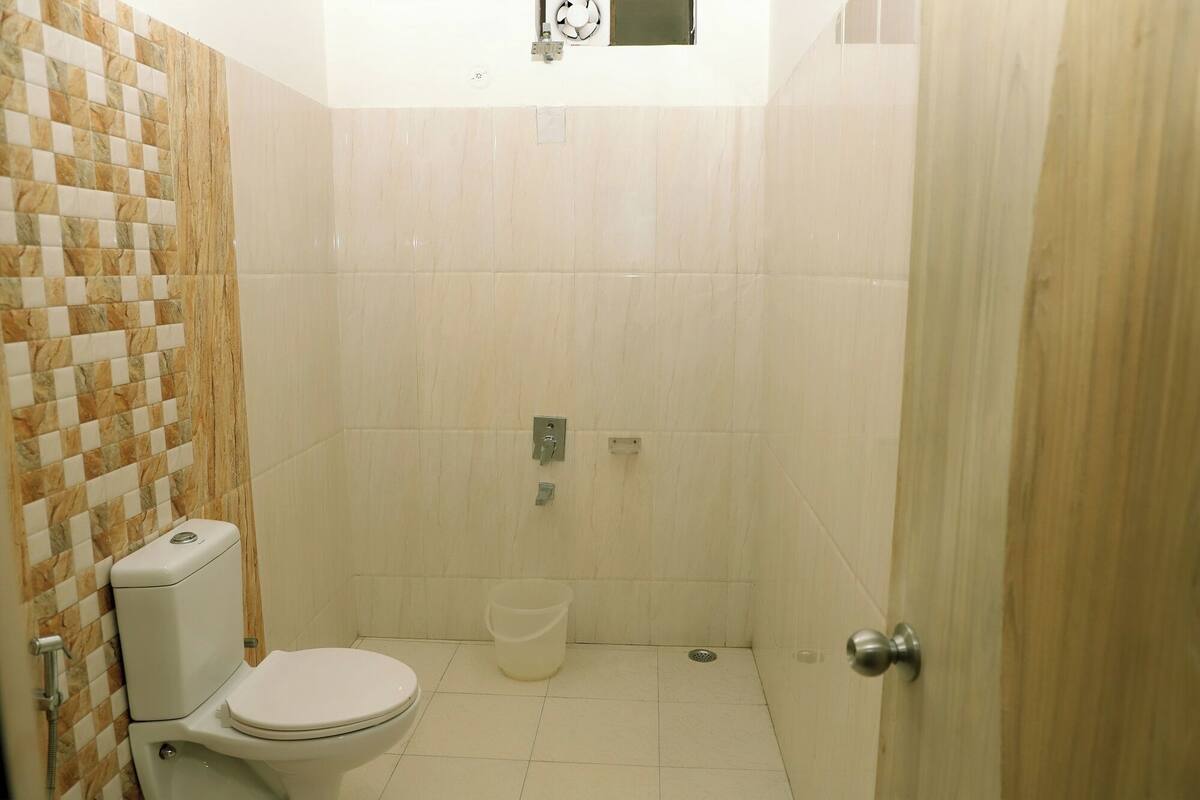 Un bagno piccolo rivestito di piastrelle, con il water, una doccia e un catino.