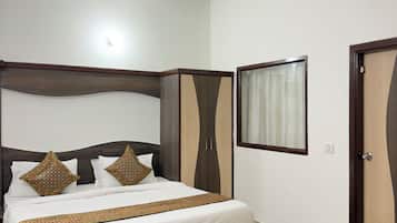 Un dormitorio con cama, ventilador de techo, armario y ventana con cortinas.