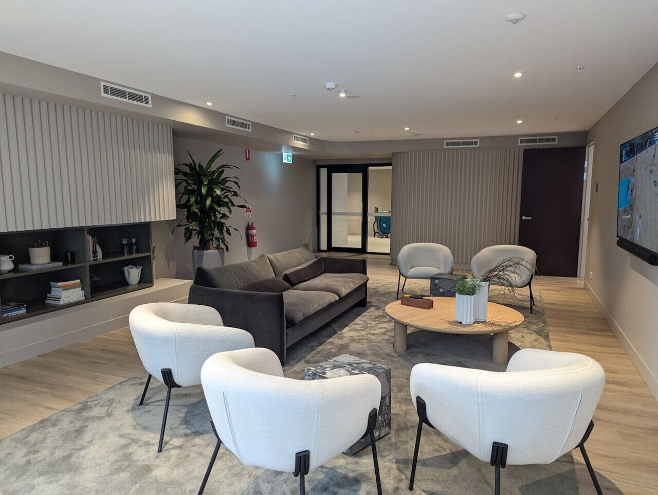 Uma área de estar moderna com sofá, poltronas e mesa de centro.