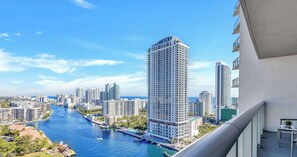 Hotel alto com vista para um rio e outros edifícios.