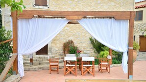 Eine Außenpatio mit Pool, Holzmöbeln und einer Steinmauer.