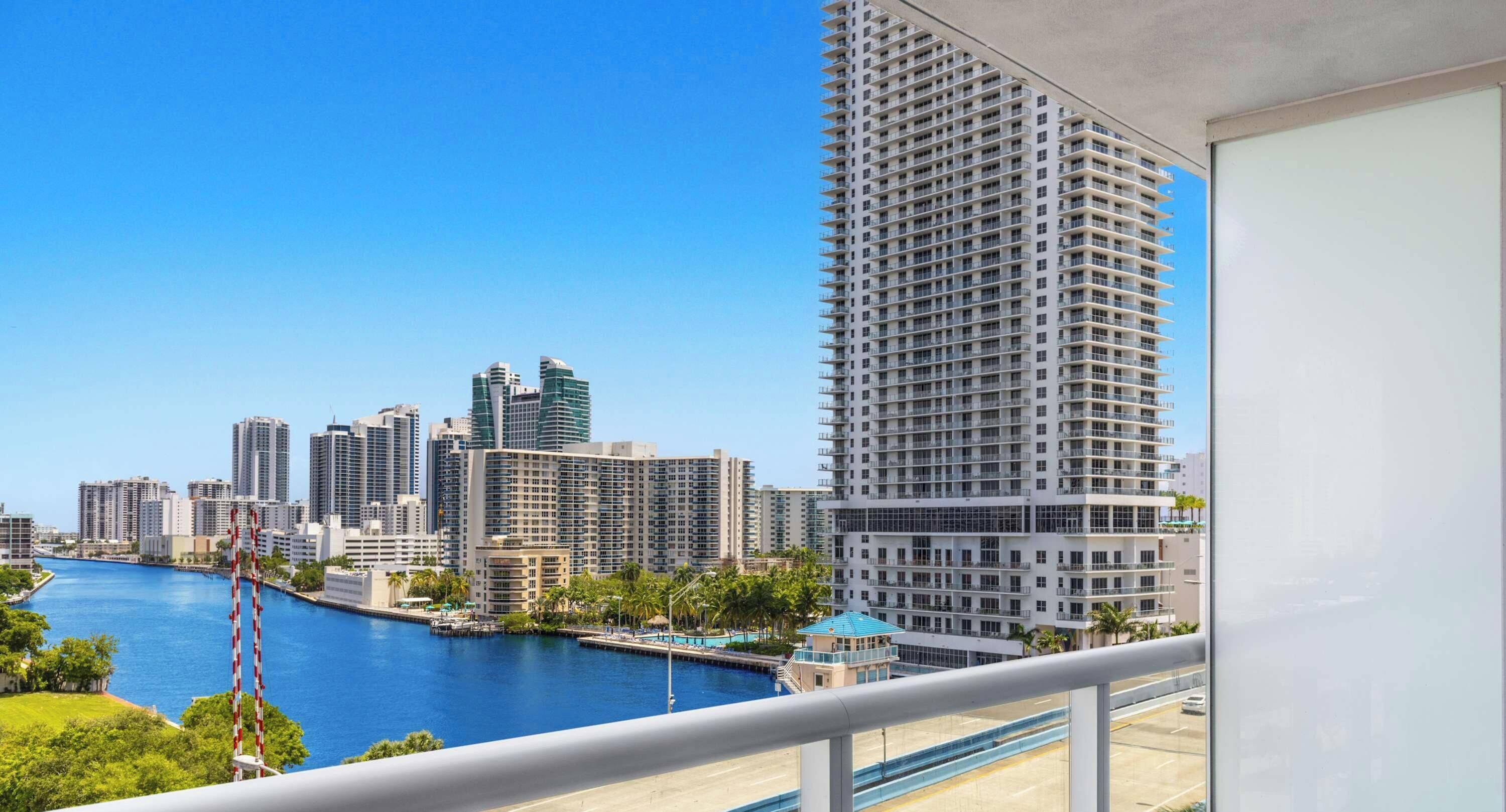 Un edificio alto con vista al horizonte urbano y una masa de agua.