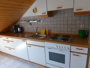Een koelkast, een oven, een kookplaat, een koffiezetapparaat/waterkoker