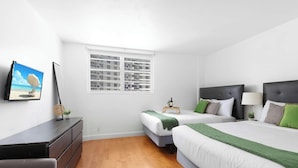 Un dormitorio con dos camas, un aparador, una ventana con persianas y un cuadro en la pared.