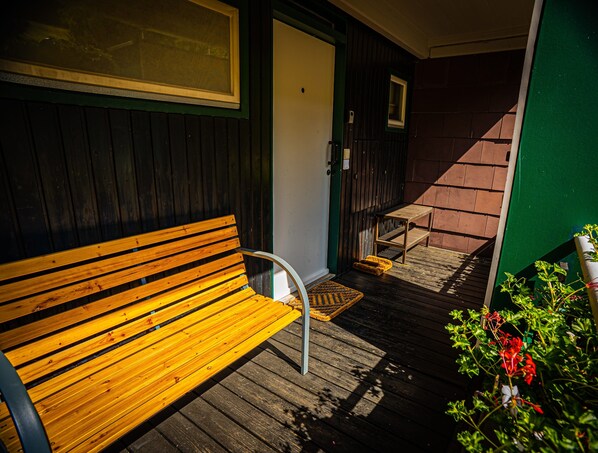 A wooden bench, a door, a small table, and a staircase leading to an upper level.