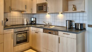 A modern kitchen with stainless steel appliances, a dishwasher, and a coffee maker.