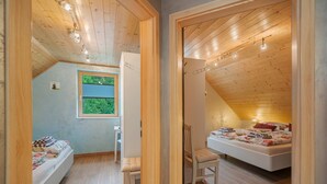 Une chambre avec un lit en mezzanine, un bureau et une fenêtre donnant sur un paysage verdoyant.
