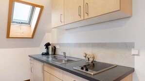 A modern kitchen with a skylight, a built-in stove, and wooden cabinets.