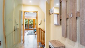 A hallway with a wooden bench, a door, and a view of an outdoor area. - Apartment 'Lütt Stuv' with Private Terrace, Shared Garden, and Wi-Fi (Fockbek)