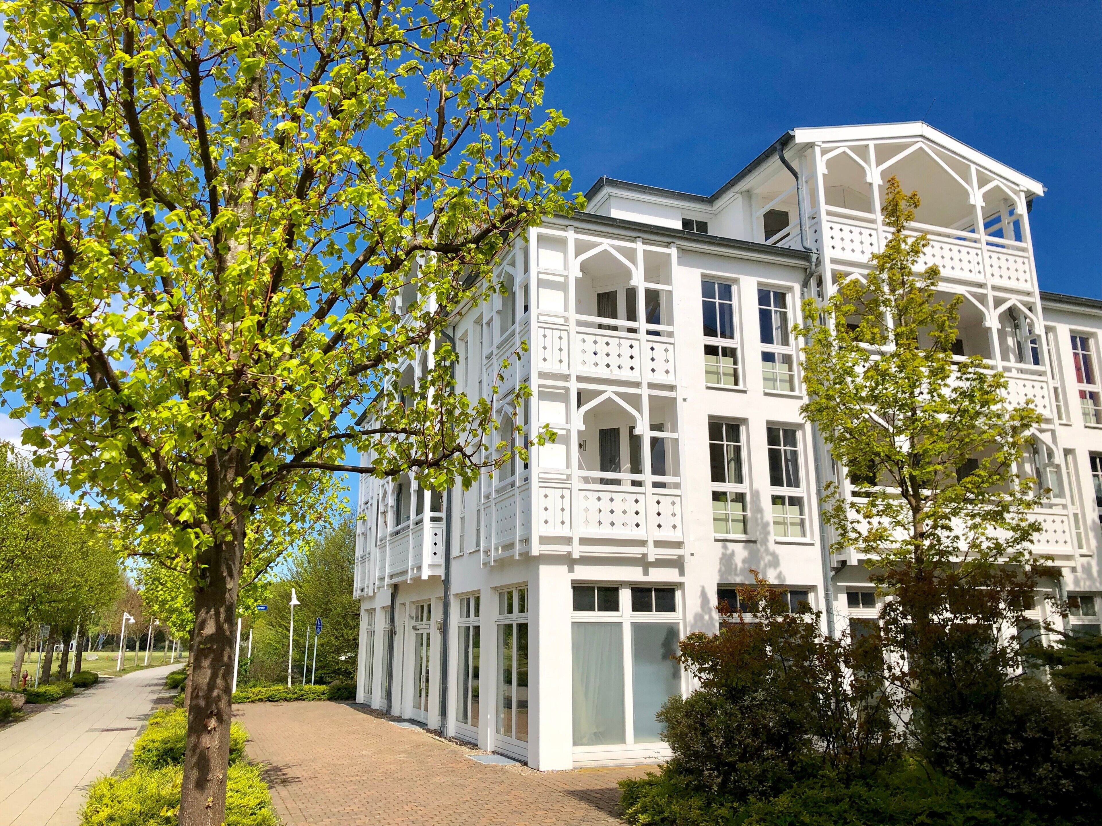 Ein weißes Mehrgeschosshaus mit großen Fenstern und Balkonen.