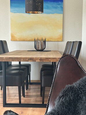 A dining area with a wooden table, black chairs, and a decorative bowl.