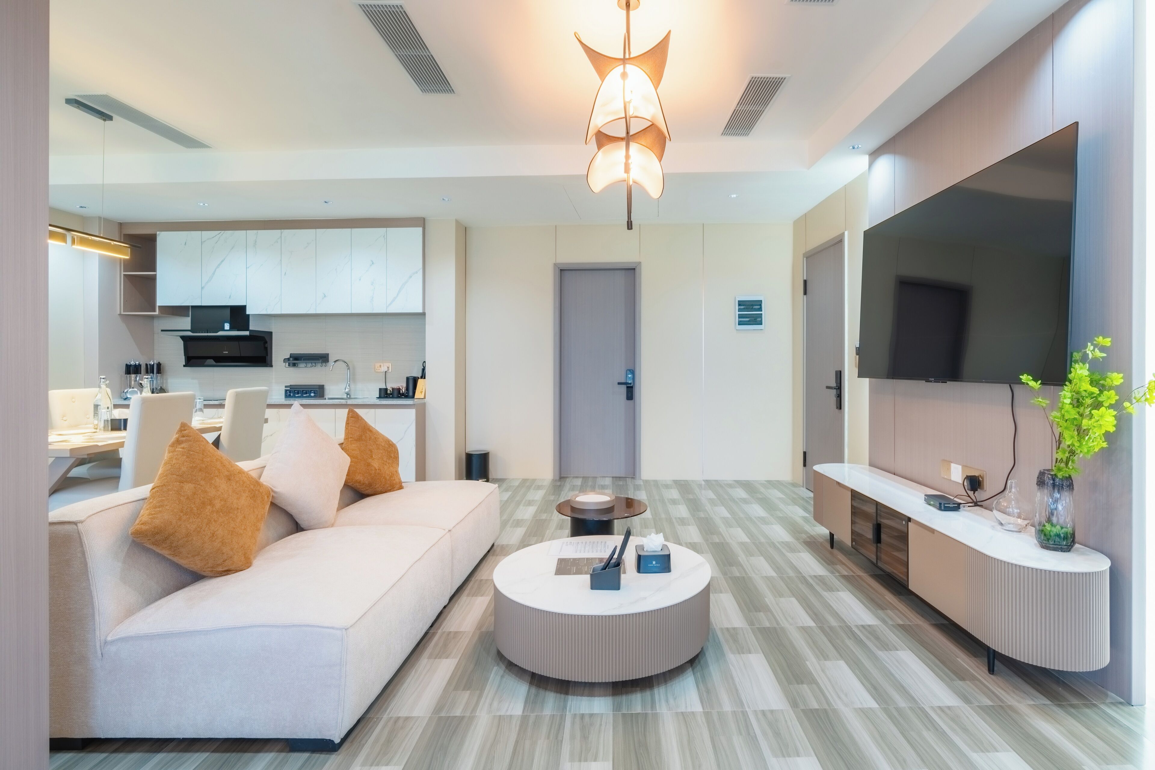 A modern living room with a sofa, coffee table, and a flat-screen TV.