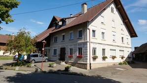 A two-story building with a sloped roof, multiple windows, and flower boxes on the ground floor. - Holiday Apartment 'A' with Balcony and Wi-Fi (Langenargen)