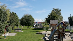 A playground with swings, a slide, and a small wooden structure. - Apartment 'C' with Wi-Fi (Langenargen)