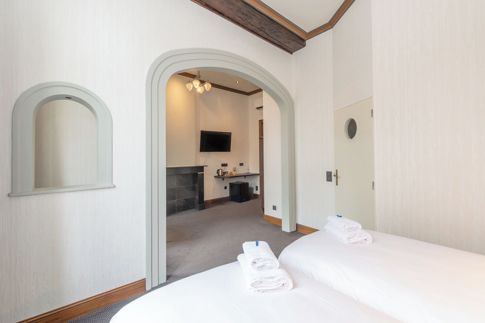 Une chambre d’hôtel avec deux lits, une salle de bain et un téléviseur.