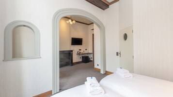 Une chambre d’hôtel avec deux lits, une salle de bain et un téléviseur.