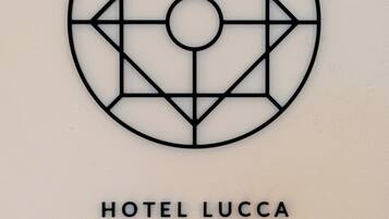 Un logotipo geométrico con el texto "HOTEL LUCCA" debajo.