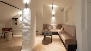 Una sala moderna con un sofá, una mesita y una silla.