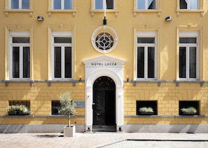 A yellow building with a sign reading 'HOTEL LUCCA' above the entrance. - Hotel Lucca (Bruges)