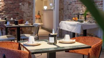 A restaurant setting with tables and chairs, a coffee machine, and a menu stand.