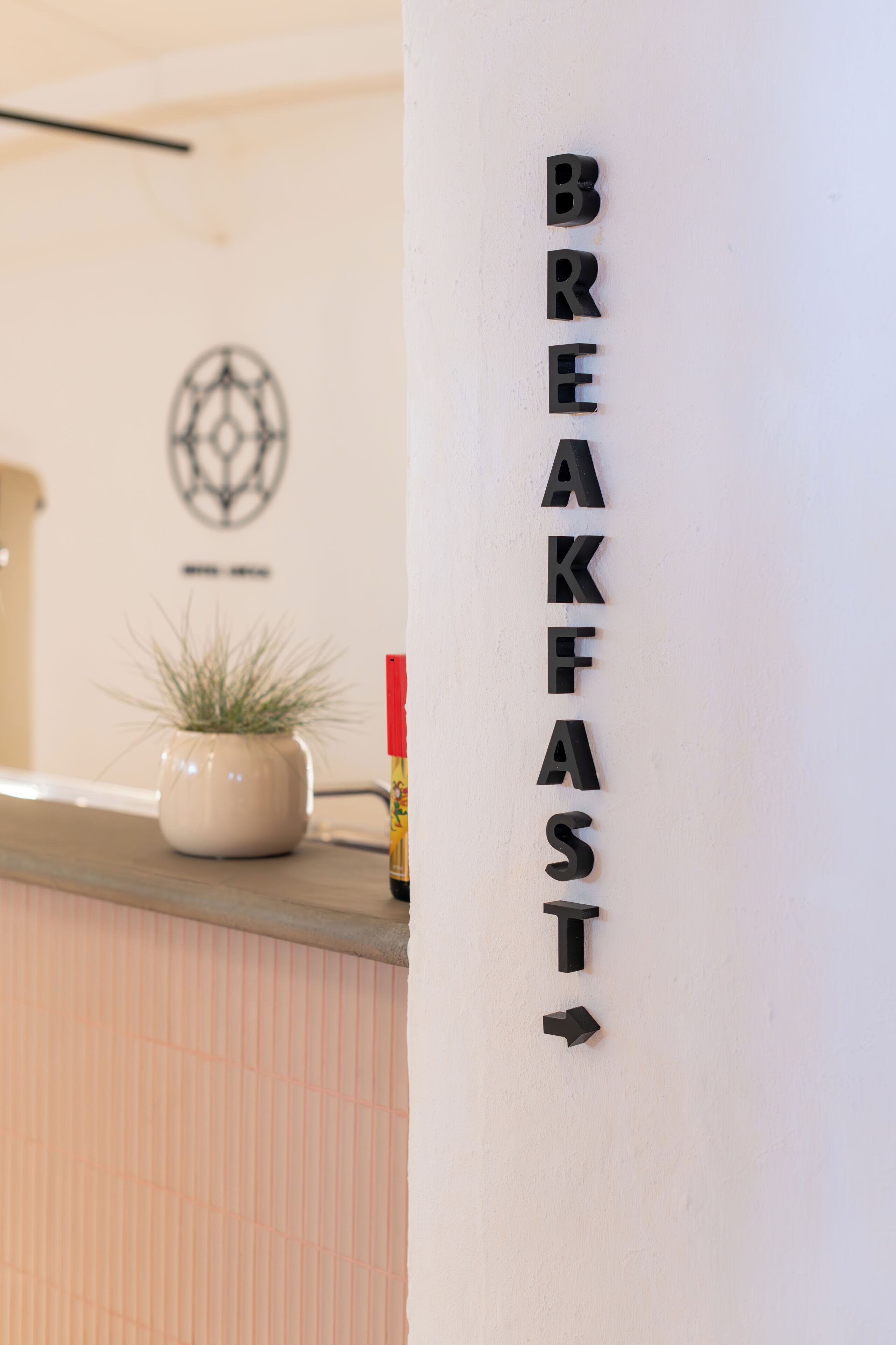 Eine Wand mit dem Wort 'BREAKFAST' in großen, fetten Buchstaben, das auf einen Frühstücksbereich hinweist.