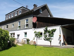 Une maison à deux étages avec un garage, une antenne parabolique et une pelouse bien entretenue.