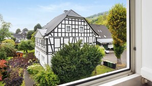 A traditional half-timbered house with a visible garden and a clear view of the surrounding area. - Apartment '2 Bergblick, 60sqm' with Mountain View, Shared Garden and Wi-Fi (Lennestadt)