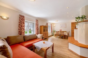 A cozy living room with a sofa, a table, and a cabinet. - Holiday Home 'Becker' with Private Terrace, Private Garden and Wi-Fi (Schönau (Pfalz))