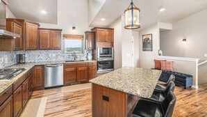 A modern kitchen with wooden cabinets, granite countertops, and stainless steel appliances. - Ayu Ranch | Panoramic views | Hot tub (Cheyenne)