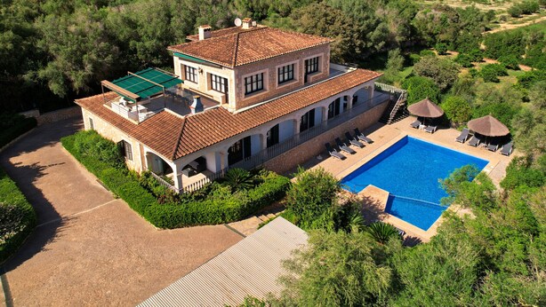 A large house with a swimming pool, surrounded by lush greenery and a scenic landscape. - Pleta - Rustic villa in Petra with private pool and beautiful views (Petra)
