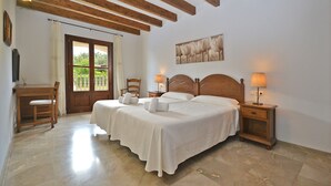A double bed with two bedside tables, a wooden desk, and a chair. - Pleta - Rustic villa in Petra with private pool and beautiful views (Petra)