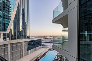 Un edificio moderno con piscina en la azotea y vistas panorámicas de la ciudad.
