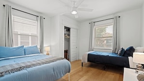 Ein Schlafzimmer mit zwei Betten, einem Kleiderschrank und einem Deckenventilator.