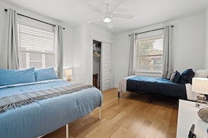 Un dormitorio con dos camas, un armario y un ventilador de techo.