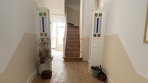 A staircase with a patterned floor leading to a door at the top.