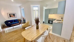 A modern apartment with a dining area, a kitchen, and a living room.