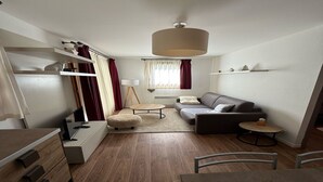 Un salon moderne comprenant un canapé, une table basse et un coin repas avec une table et des chaises.