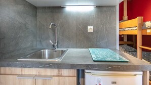 A compact kitchenette with a stainless steel sink, a microwave, and a small refrigerator. - Studio in Chamrousse near Ski Resort (Chamrousse)