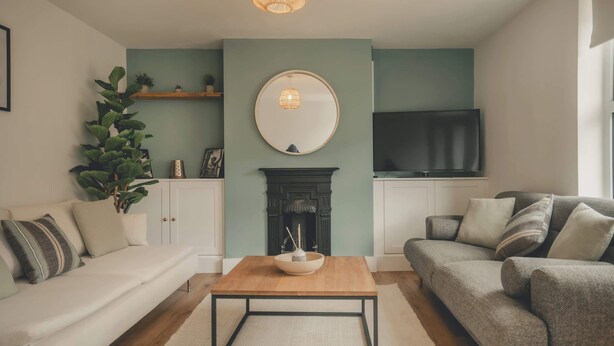 A living room with a sofa, a coffee table, a fireplace, and a television. - Modern 3BR Home with Stunning Garden | Banbury Stay (Banbury)